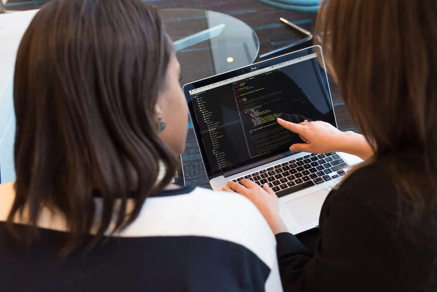 Developers reviewing software on a laptop, a stock photograph